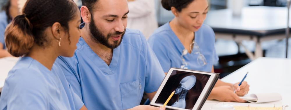 Three medical students examining an x-ray