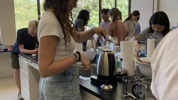 UC Davis Pre-College student adds water to the coffee pot