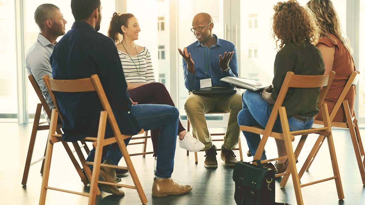 a group of people sit in a circle talking