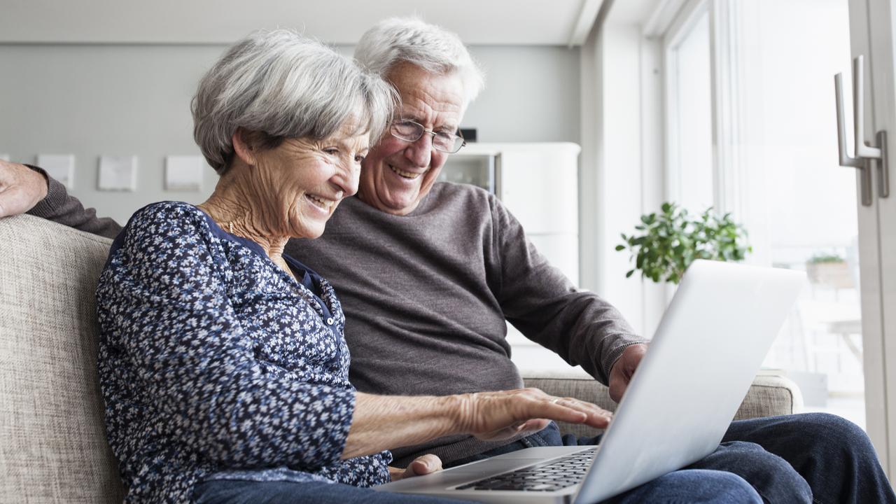 happy senior couple on computer