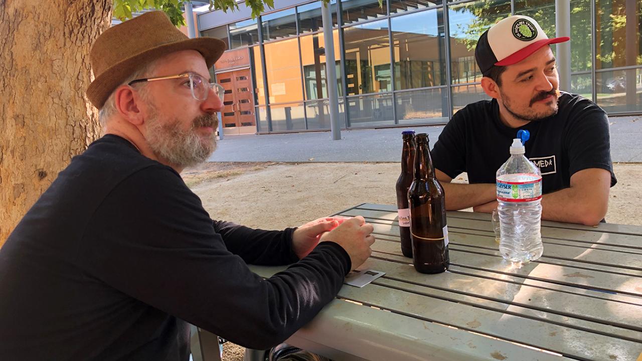 online Master Brewers grad Alex Kandel shares his homebrews with a fellow brewing classmate