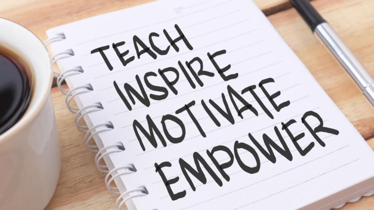 A notebook with teach, inspire, motivate and empower written on the page next to pen and coffee