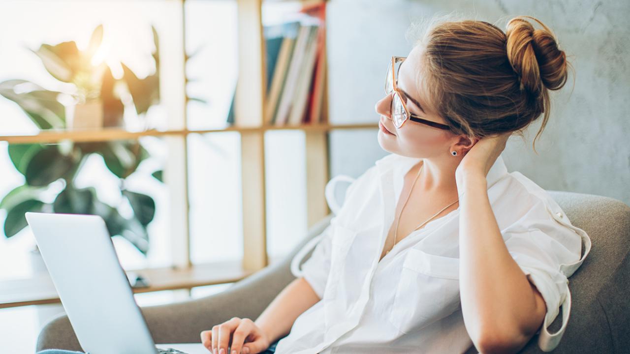 a woman sits at home with her laptop
