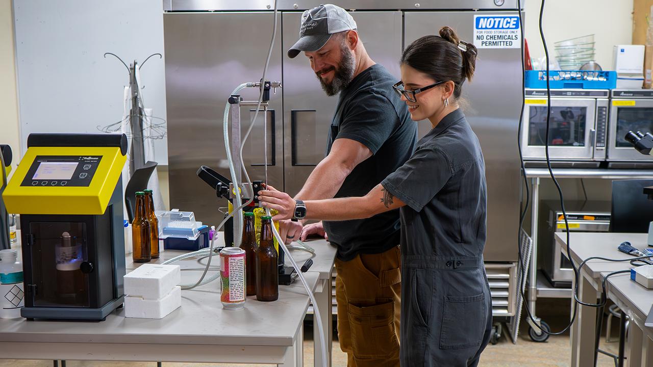UC Davis Master Brewers Program grads Giuliana and Greg in the pilot brewery lab on campus