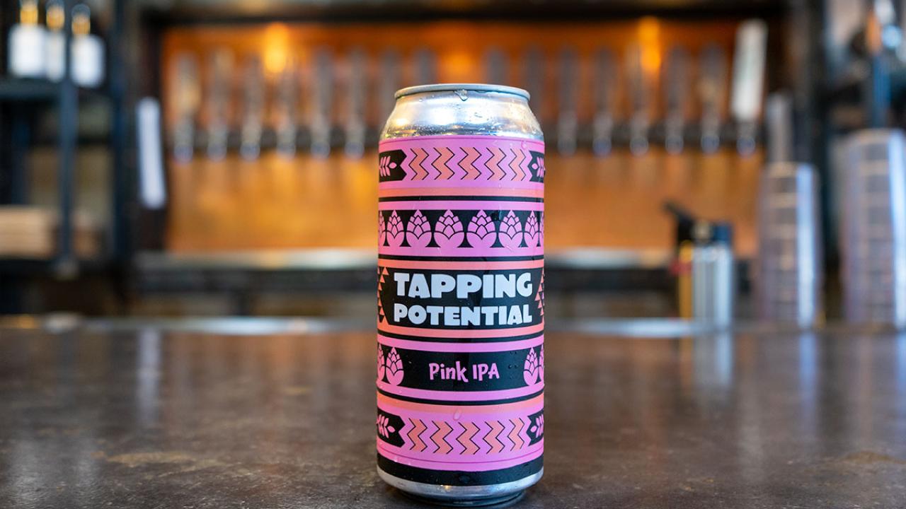 Hero shot of Tapping Potential Pink IPA can on a bar top