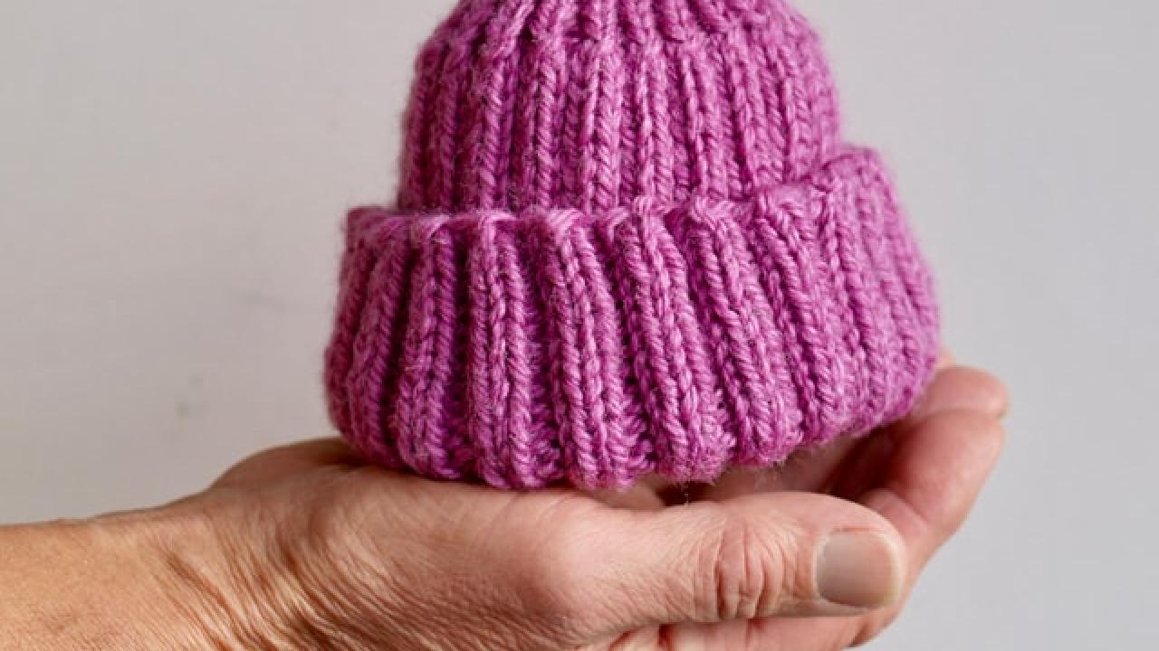 image of hand holding knitted hat