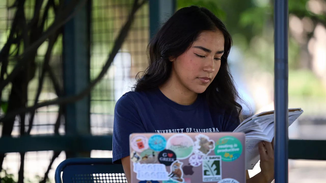 UC Davis student looking at her laptop outside