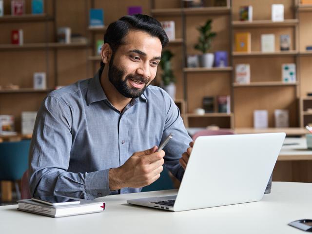 Student sitting at computer at home engaged in online learning or training