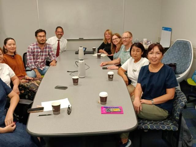 A group of people in a conference room facing front.