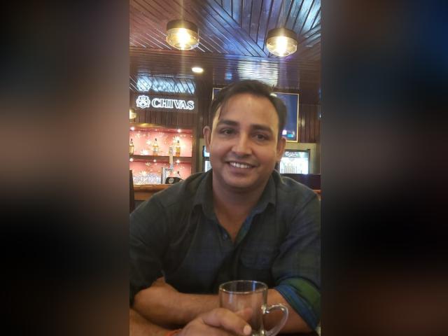 Rajesh, CPE project management student, smiles for the camera in a bar