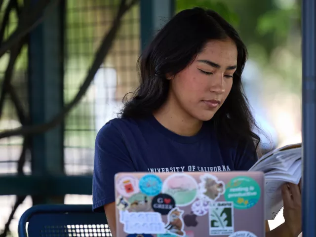 UC Davis student looking at her laptop outside