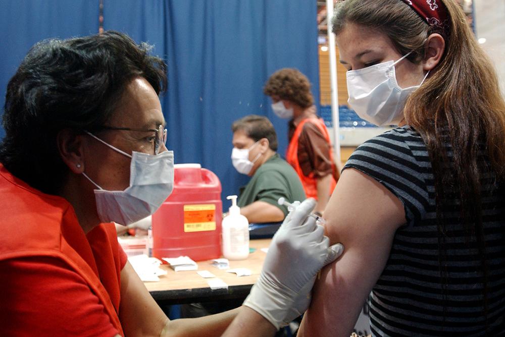 a public health nurse gives a vaccine