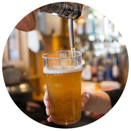man pouring a beer from a tap at a bar