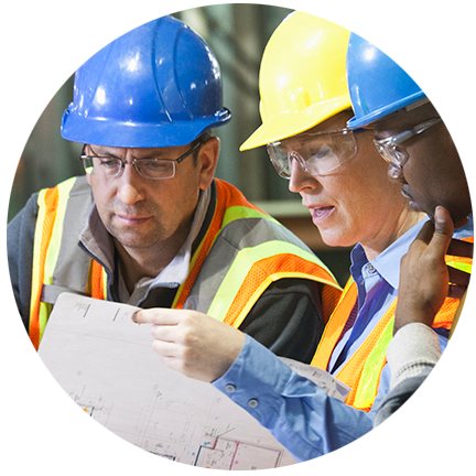 three construction workers in hardhats looking over blueprints