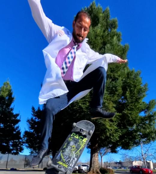 Dr. Patel skateboarding in his white coat