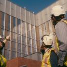 construction workers look up at a building