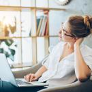 a woman sits at home with her laptop