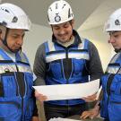 UC Davis CPE Construction Management Certificate Program grad Camilo Renteria, center, poses with his team while looking at construction plans