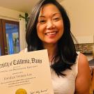 Kandice Lee smiles and holds her certificate showing that she has completed the Construction Management program