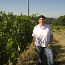 UC Davis Winemaking Certificate grad Mariachiara poses in front of vineyards near her house in Fiorentini