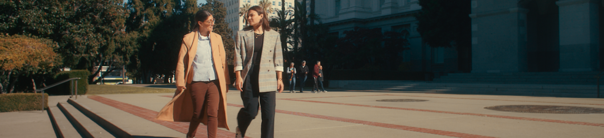 Two people walking on campus.