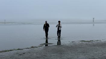 A UC Davis Pre-College student and TA wade through the mud flats after collecting specimens