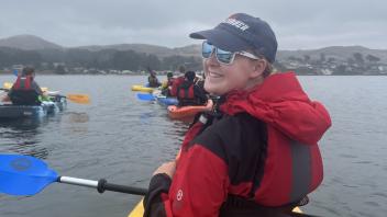 A UC Davis Pre-College student turns to pose while kayaking in Bodega Bay