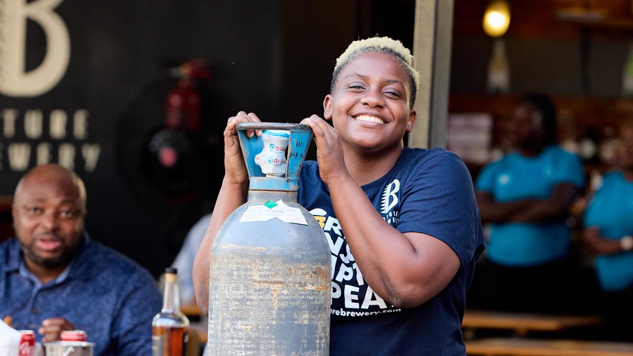 Tapping Potential Scholarship winner Chijindu Onwuchekwa poses with keg