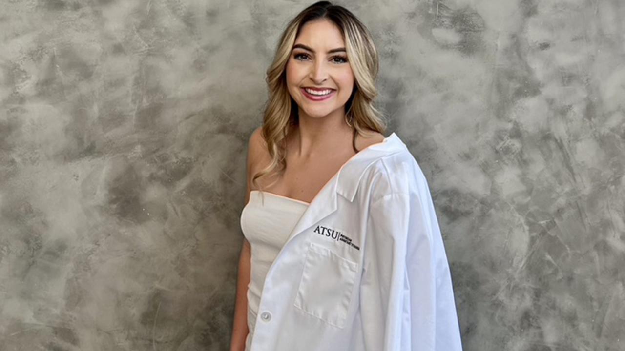 UC Davis Health Professions Post-Bac student Gabby Rich poses in her white coat