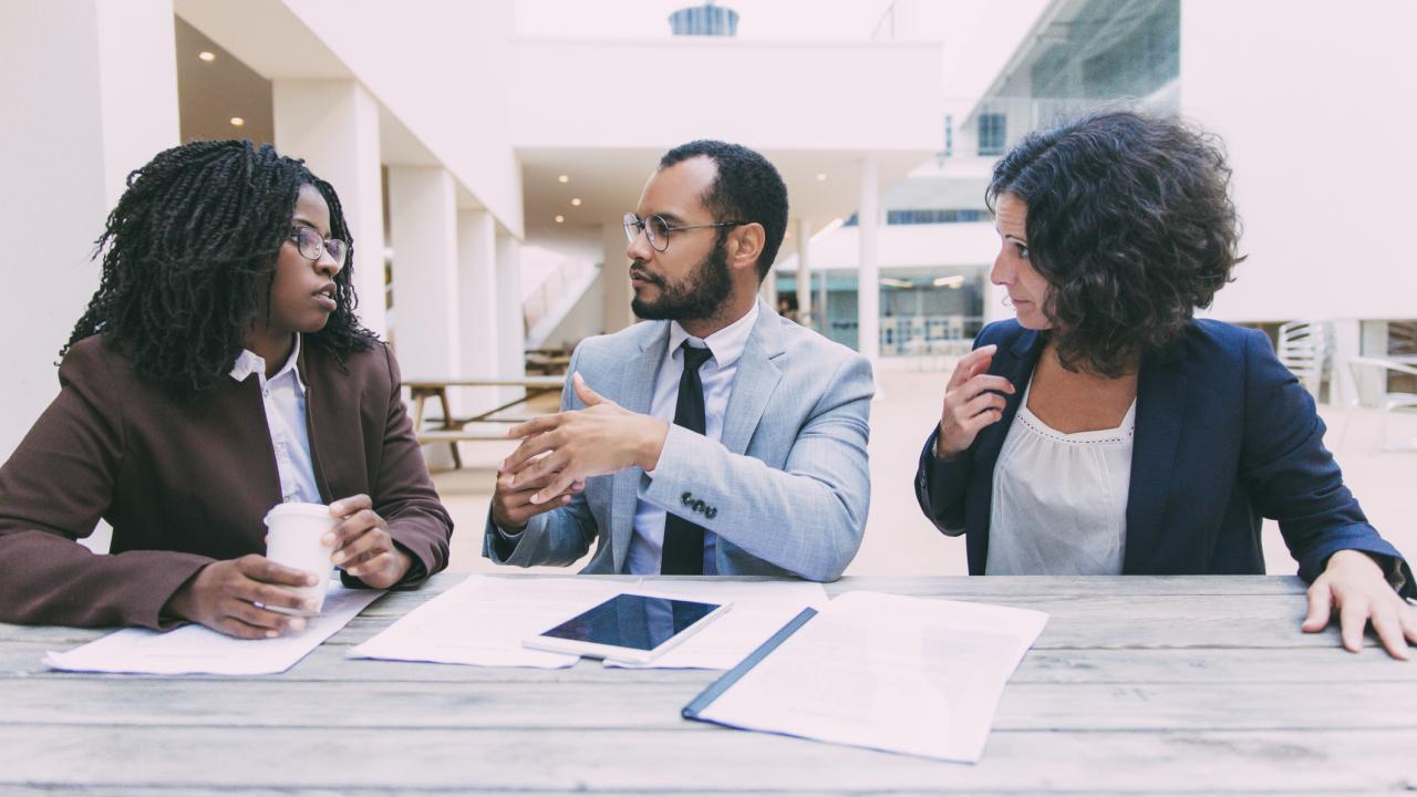 Three colleagues have a workplace discussion