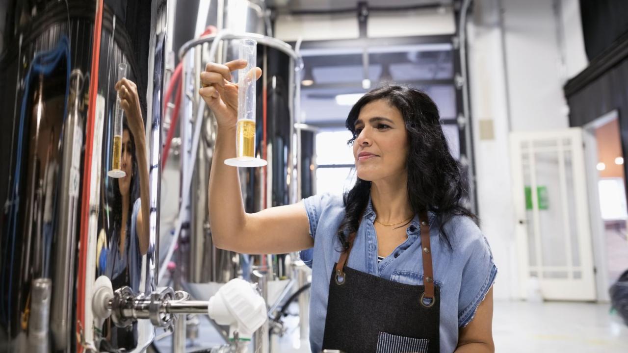 Brewer looking at a glass of possible brew