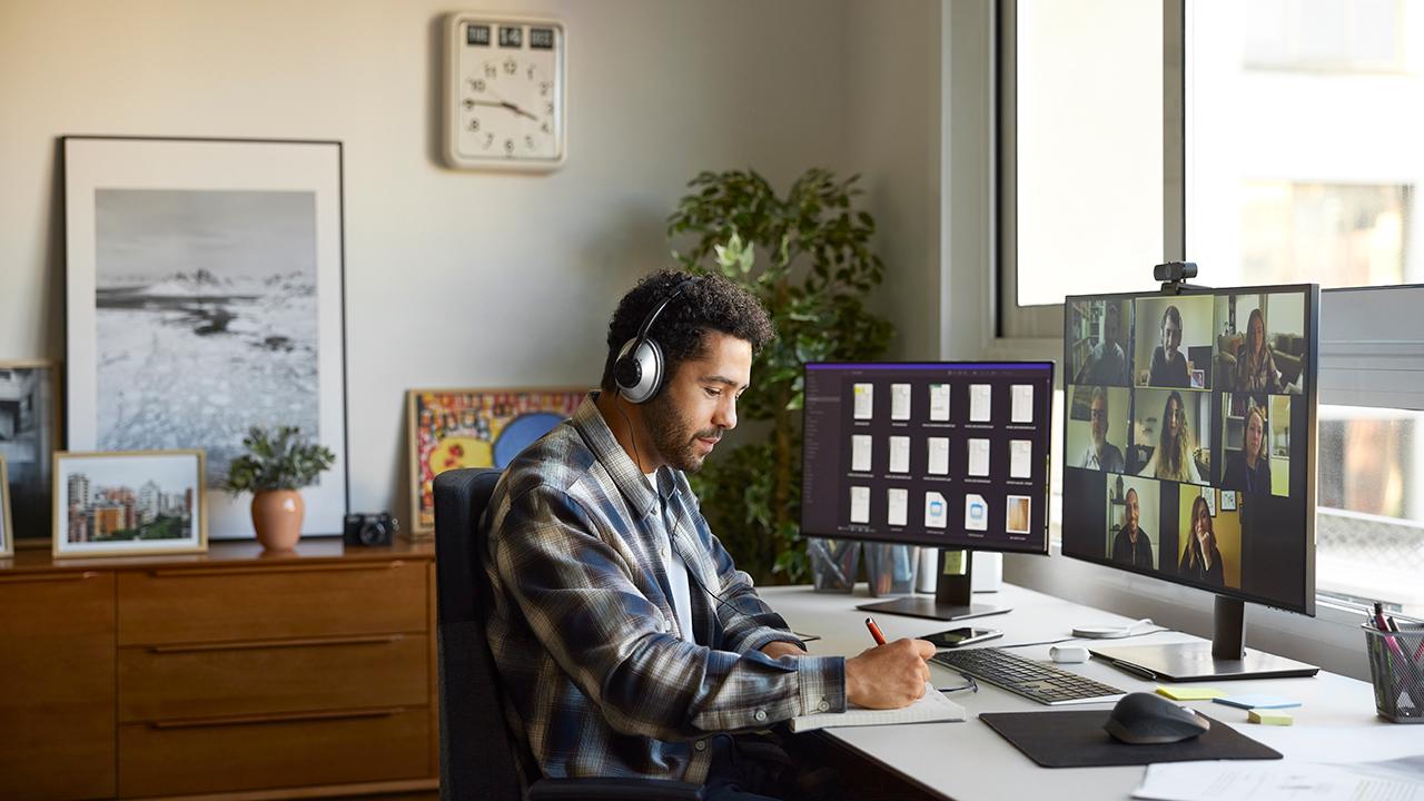 man wearing headphones at desk participating in online class