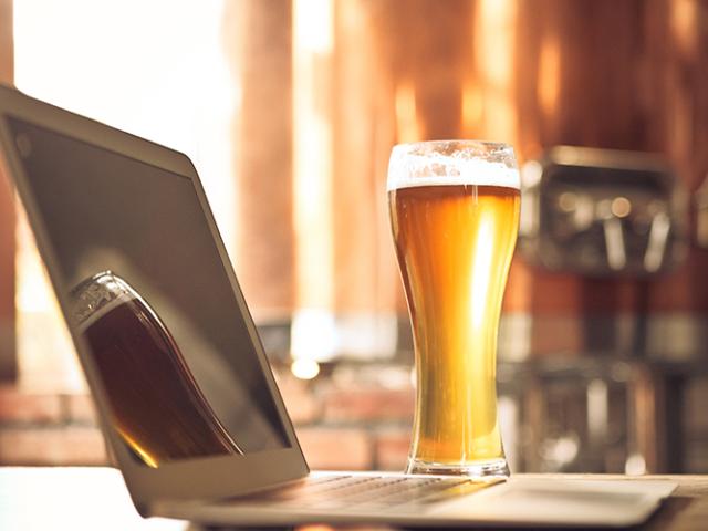 laptop and glass of beer on a desk