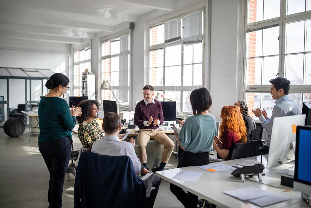 colleagues in office sitting in circle and applauding