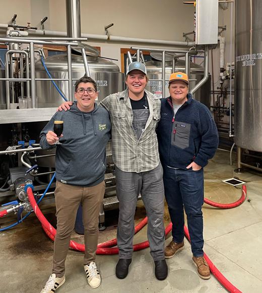 Three UC Davis Master Brewers grads pose in a brewery