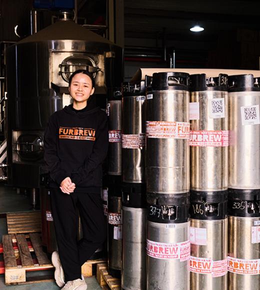 UC Davis Tapping Potential Scholarship winner Dung Ngo poses in the Furbrew Brewery with kegs