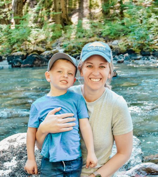 Healthcare Analytics Certificate grad Kate Guzowski poses with son in front of river