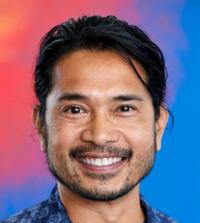 A head shot of Mikael Villalobos against a blue and orange background