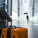 Man wheeling suitcase in airport terminal