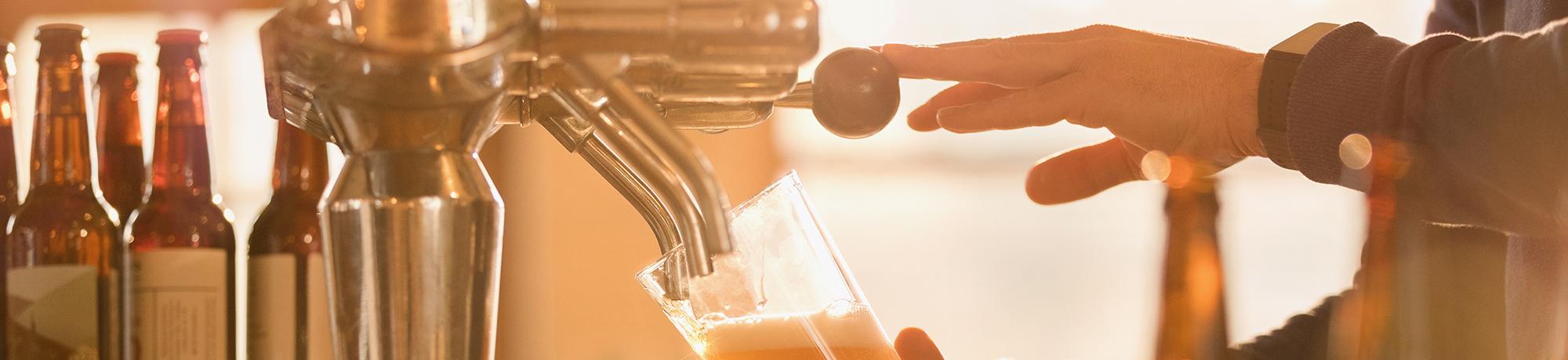 man pulling a beer tap